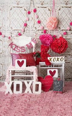 valentine's day decorations are displayed in front of a wall with hearts and flowers