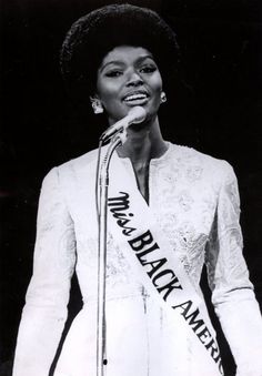 an old black and white photo of a woman holding a microphone