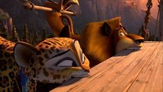 two animated animals sitting on top of a wooden table next to each other in the jungle