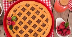 a pie with chocolate and raspberries in it on a table next to other desserts