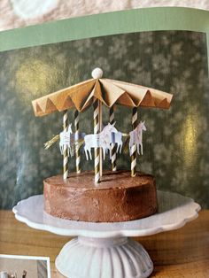 there is a cake decorated with horses on it and an umbrella topper in the middle