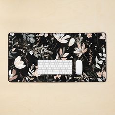 a computer mouse pad with a floral pattern on it and a keyboard in the middle