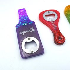 three different colored bottle openers sitting next to each other