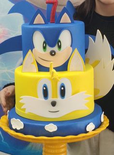 a person holding a cake with sonic the hedgehog on it