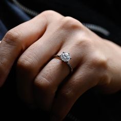 a woman's hand with a diamond ring on it