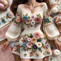 the doll is wearing a white dress with flowers on it's chest and arms