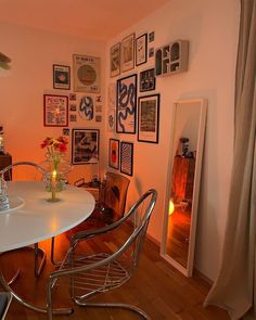 a dining room table with chairs and pictures on the wall