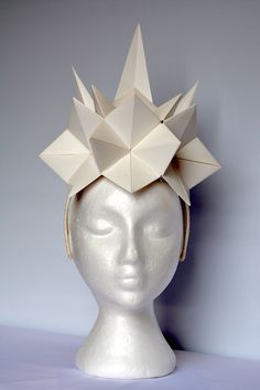 a white mannequin head wearing a paper crown