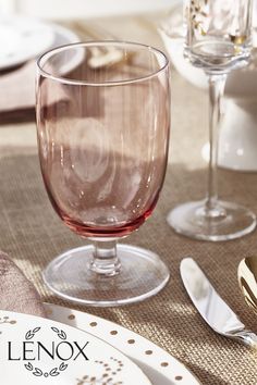 there is a wine glass on the table with silverware next to it and two empty glasses