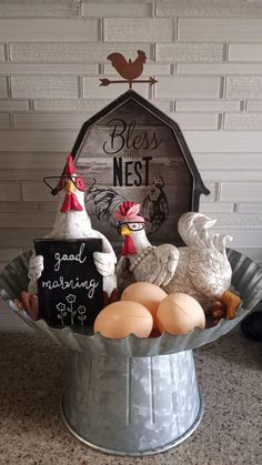 a metal bucket filled with eggs and chickens next to a sign that says, best nest