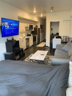 a living room filled with furniture and a flat screen tv mounted to the side of a wall