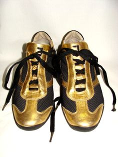 Janet Sport Gold Laminated & Black Techno Fabric Lace Sneakers European Size 36 Or U.S. Size 6! See The "J" Flap Monogram! Condition Is Very Good To Excellent Pre-Owned!  Very Faint Tip Discoloration!  The Camera Flash Makes It Look More Distinct, But In Normal Lighting It Is Not Really Noticeable Unless You Are Looking Very Close!  PLEASE BUY NEW SHOE LACES!  The Laces Are Too Long & Show Wear From The Sneakers Being Used With The Long Laces!  Very Clean, Inside & Outer!  Please Take A Moment T Sporty Gold Sneakers With Perforations, Gold Sporty Running Sneakers, Lace Sneakers, Camera Flash, Too Long, Being Used, New Shoes, Shoe Laces, Laminate