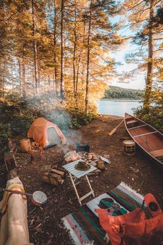 there is a camp site with a tent and canoe on the ground