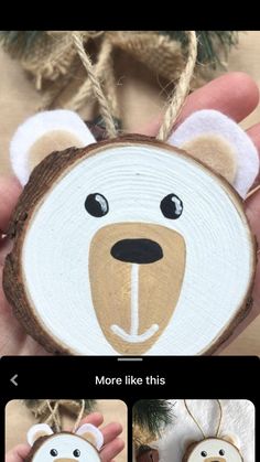 a hand holding a wooden ornament with a bear on it's face