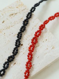 Intensify your style with our Braided Double Red Black Onyx Beaded Necklace! Made with natural red and black onyx, the twisted and woven design exudes passion and mystery. Paired with a silver OT buckle, this necklace is a must-have statement piece. Ignite your aura, elevate your look, and stand out from the crowd. Highly recommended for a bold and captivating appearance! Metal: Recycled Sterling Silver Plated On Brass Gemstone: Red/Black Onyx Length: 400mm Weight: 10g Knitted Choker, Edison Pearls, Gemstone Beaded Necklace, Onyx Bead, Tiger Eye Stone, Woven Design, Beaded Necklaces, Beaded Choker, Recycled Sterling Silver