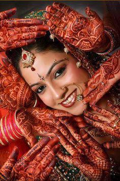 a woman with her hands on her face and arms covered in hendikes, smiling for the camera