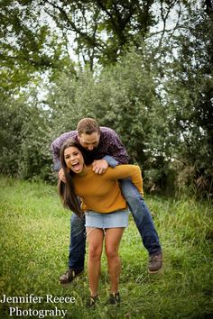 two people hugging each other while standing in the grass