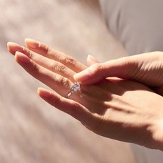 a woman's hand with a diamond ring on it