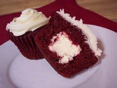 two red velvet cupcakes with white frosting on a plate