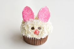 a cupcake with white frosting and pink ears