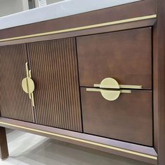 a wooden cabinet with brass handles and knobs on the doors is shown in this image