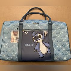 The Primark Disney Weekender Travel Bag Is Perfect For Any Lilo And Stitch Fan Who Loves To Travel In Style. The Baby Blue Exterior Color Is Accented With Cute Stitch Stitching, And Is Made Of A Durable Polyester Material. The Duffel Style Has Plenty Of Room For All Your Essentials And It’s Perfect For A Weekend Getaway Or A Long Vacation. One Inside Zip Pocket And One Exterior Zip Pocket. Approximate Measurements Are 18“ W. 11” H. 7” D 100% Pvc Stitch Furniture, Disney Singing, Stitch Things, Uni Bag, Disney Minnie Mouse Ears, Stitch Stuff, Clear Cosmetic Bag, Blue Exterior, Sally Nightmare Before Christmas