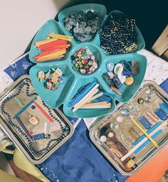 the trays are filled with different types of beads, pens and pencils in them