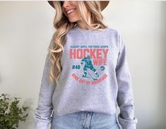 a woman wearing a hockey sweatshirt and jeans