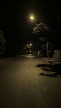 an empty street at night with the light turned on and no one is in it