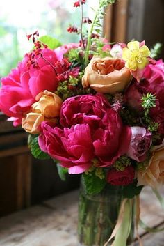 a vase filled with lots of different colored flowers