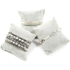 three white pillows with silver beading on them