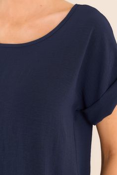 Elevate your wardrobe with our Elevated Classic Navy Short Sleeve Top. This versatile piece is perfect for any occasion. With its elevated and unique design, you'll stand out from the crowd while feeling comfortable and confident. Grab yours today and experience the perfect blend of style and comfort. This top features a crew neckline, a folded cuff sleeve, and an intentional back seam detail. 100% Polyester Hand Wash Cold Unlined Imported Model is wearing a size small Navy Summer T-shirt, Navy Crew Neck T-shirt For Summer, Summer Cotton T-shirt With Curved Hem, Cotton T-shirt With Curved Hem For Summer, Casual Navy Summer T-shirt, Casual Summer T-shirt With Curved Hem, Summer Cotton Tops With Curved Hem, Relaxed Fit Top With Rolled Sleeves For Summer, Casual Tops With Rolled Sleeves For Loungewear