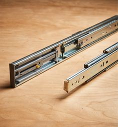 two pieces of metal sitting on top of a wooden table