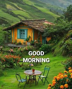 a small yellow house sitting in the middle of a lush green field with flowers on it