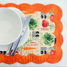 an orange place mat with a bowl, fork and spoon on it