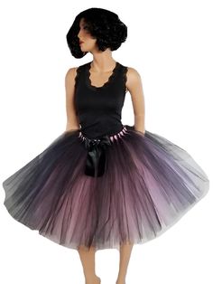 Experience the allure of our exquisite Mauve and Black Tulle Skirt, a harmonious fusion of beauty and grace. Crafted to perfection, this resplendent tutu captures attention with its enchanting design and meticulous details. The skirt's unique charm lies in its meticulously hand-tied strips of tulle, elegantly arranged in a single layer upon a flexible elastic waistband. This construction not only ensures a captivating fullness but also guarantees comfort as you glide through any occasion with poise. Complementing this masterpiece is a sophisticated black double-sided satin bow, a tasteful accessory that adds a touch of refinement to the ensemble. Positioned flawlessly, this bow mirrors the skirt's charm and completes your look with a sense of polished elegance. An ingenious design element Elegant Halloween Party Skirt, Elegant Fitted Tutu Dress For Costume Party, Elegant Black Petticoat For Party, Elegant Black Tulle Petticoat, Elegant Black Party Petticoat, Wedding Black Tulle Petticoat, Black Tulle Petticoat For Evening, Black Tulle Petticoat For Wedding, Black Tulle Skirt For Halloween