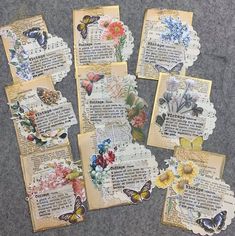 several pieces of altered paper with flowers and butterflies on them are laid out in rows