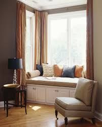 a window seat with pillows on it next to a lamp