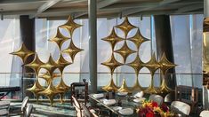 the dining room is decorated with gold and white furniture, along with large windows that look out onto the ocean