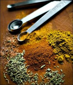 various spices and spoons on a wooden table