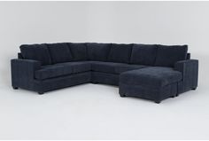 a large blue sectional couch sitting on top of a white floor next to a chair