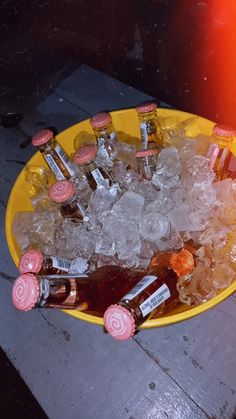 a yellow bowl filled with lots of ice and bottles