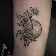 a black and white photo of a pomegranate tattoo