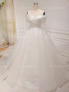 a white wedding dress on display in a room