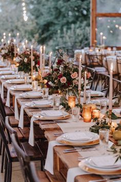 a long table is set with candles and place settings for dinner guests to sit at