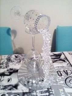 there is a wine glass on top of the table with beads and pearls around it