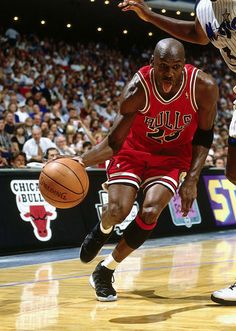 two men playing basketball in front of an audience