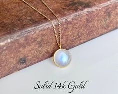 Rainbow Moonstone Necklace, Solid 14k Gold Pendant, June Birthstone, Real Gold Moonstone Jewelry , Birthday gift for her, Mother's Day Gift This classic minimalist necklace features a stunningly perfect flashy rainbow moonstone round puffy pendant bezeled in solid 14k gold. The blue flash moonstone pendant is suspended from a dainty solid 14k gold cable chain that come with 3 built-in adjustments to take this necklace to 16, 17 or 18 inches, whenever you needed.  Some pictures are magnified to show details, please read full description for accurate measurements, as well as all pictures on the model and the video provided. All elements of this necklace are 100% SOLID Gold. They will never tarnish or give an allergic reaction.  About this Necklace:  - Gemstone: Rainbow Moonstone - Birthstone Moonstone Round Necklace For Anniversary, Gold Moonstone Necklaces For Anniversary, Gold Moonstone Necklace For Anniversary, Moonstone Round Necklace For Gifts, Moonstone Birthstone Necklace Gift, Handmade Round Birthstone Necklace For Anniversary, White Bezel Setting Necklace For Gift, Round Spiritual Birthstone Necklace For Anniversary, Spiritual Round Birthstone Necklace For Anniversary