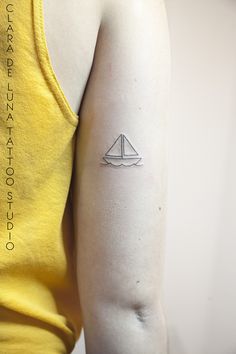 a woman with a small sailboat tattoo on her arm