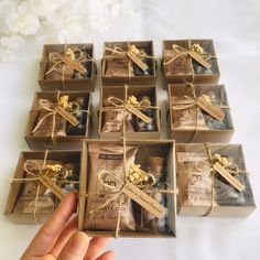 a hand is holding a box with chocolates in it and wrapped in twine